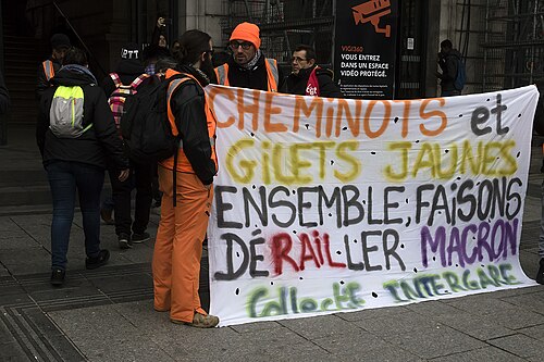 Banderole « Cheminots et gilets jaunes, ensemble faisons dérailler Macron » dans un cortège parisien.
