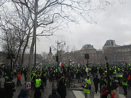 Place de la République en fin de manifestation, drapeaux et gilets jaunes.