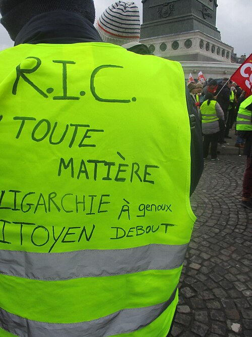 Dos d'un gilet annoté « RIC toute matière, oligarchie à genoux, citoyen debout ».