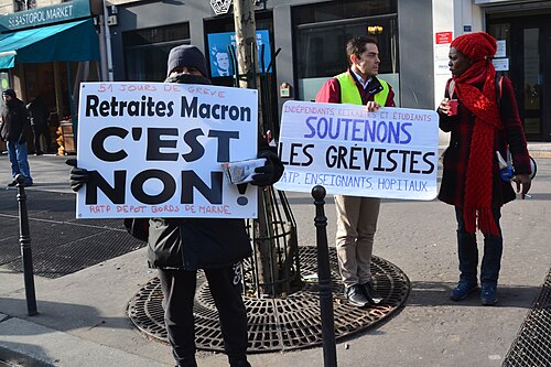 Pancartes « Retraites, Macron c'est non » et « Soutenons les grévistes » dans un cortège.